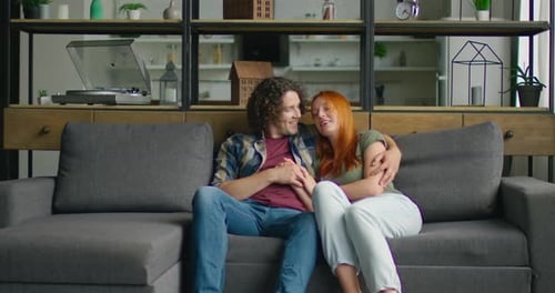 Affectionate Couple Relaxing on Couch at Home Together