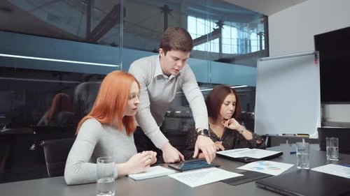 Colleagues Collaborating on Tablet in Modern Office