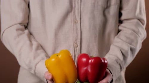 Hand hält rote Paprika oder rote Paprika mit frischem Paprika im Supermarkt