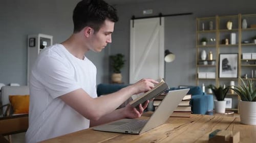 Young Man Studying with Book and Laptop