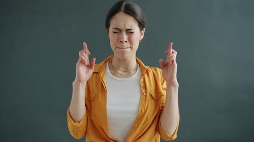 Woman Crossing Fingers Hoping for Good Luck