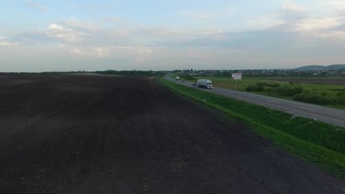 Aerial Shot of Truck Driving a Road Benween Fields