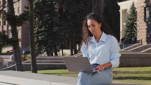 Serious Young Attractive Female Freelancer Worker Sitting Terrace in City Building Background Typing