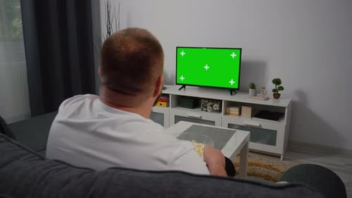 Watching Green Screen Chroma Key TV at home interior