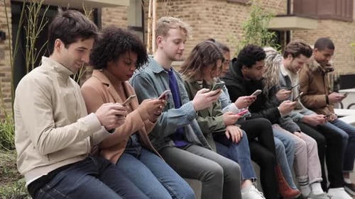 Multiracial group of friends with smartphones in the city