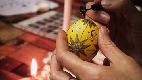 Decorating Easter Egg with Pen Under Candlelight