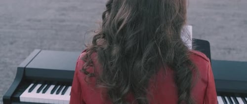 Woman Plays Piano Outside on an Overcast Day