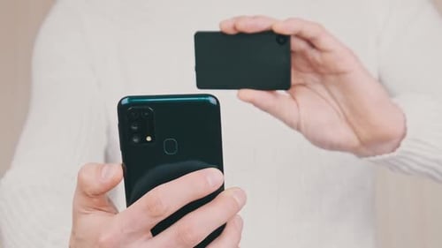 Young Man Uses Smartphone to Scan QR Code on Cold Crypto Wallet for Transaction