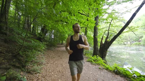 Happy young man running in the forest.