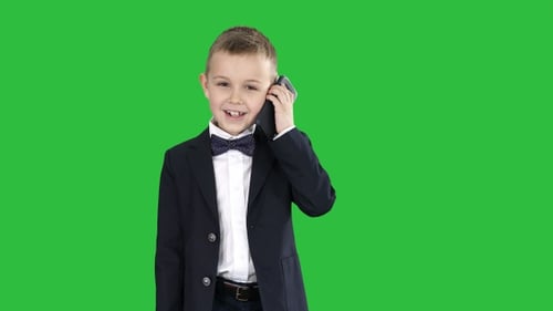 Smiling Boy in Suit Talking on Smartphone