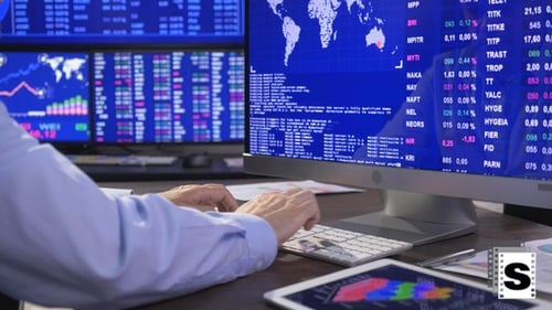 Businessman Typing in Front of Stock Market Data