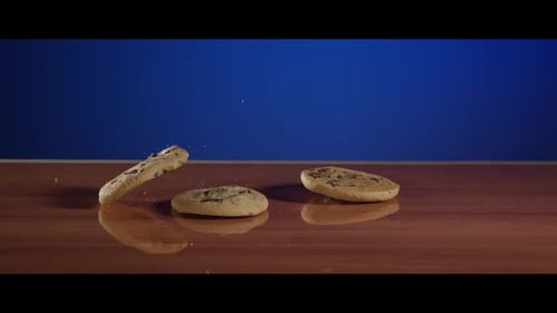 Cookies Falling onto Wooden Surface in Slow Motion