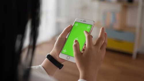 Closeup vertical of hand woman using smartphone with green screen