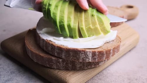 Preparing Healthy Open-Faced Sandwich With Avocado and Cream Cheese