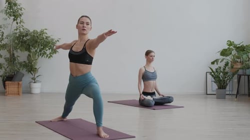 Women Practice Yoga Poses in Bright Studio