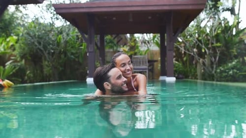 Romantic Couple Embracing in a Lush Tropical Pool