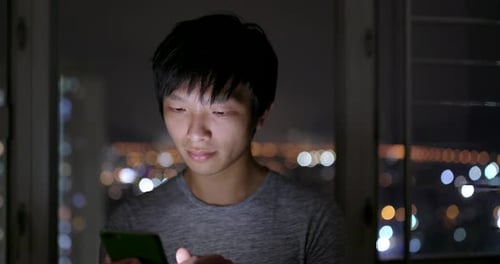 Utilisation du téléphone portable par l'homme le soir