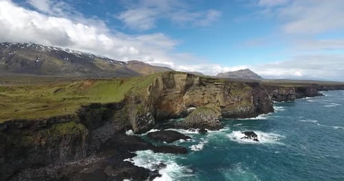 Lava cliffs at Snaefellsnes, Iceland, Snaefellsjokull volcano in the back