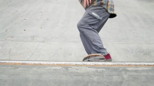Skater Practicing in the Autumn Concrete Skate Park Making Tricks and Rides in Ramp