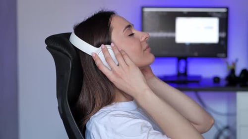 Woman Puts on Headphones and Smiles