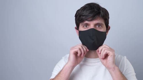 Young Adult Putting On a Face Mask