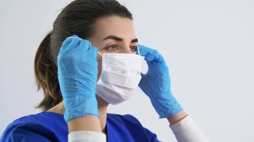 Woman Puts on Face Mask with Gloves