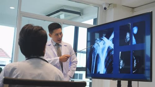Doctors Analyzing X-Rays on Monitor in Office