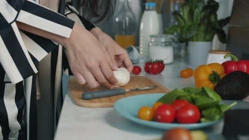 Woman Prepares Fresh Salad in Bright Kitchen
