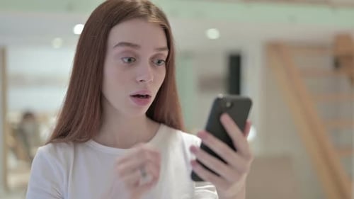 Woman Reacts with Shock to Smartphone