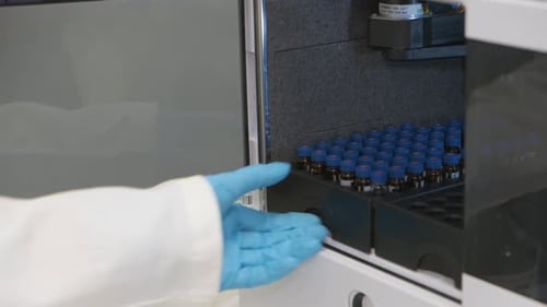 Scientist Opens Machine and Removes a Vial