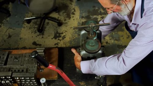 Goldsmith working on machine in workshop 4k