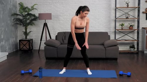 Woman Performing Standing Toe Touch at Home