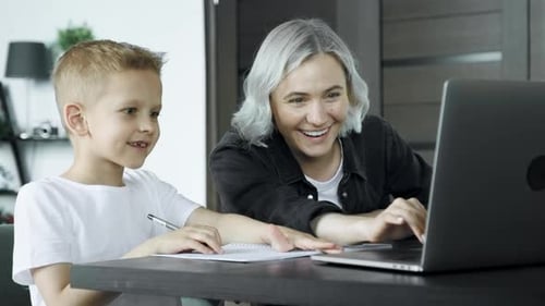 Woman and Boy Using Laptop at Home