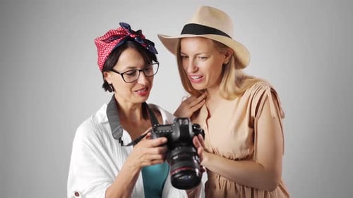 Two Women Look at Camera Display Together
