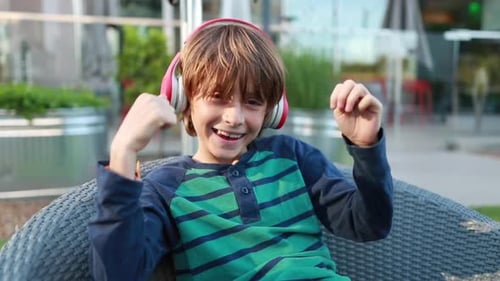 Happy Boy Listening to Music with Headphones Outside