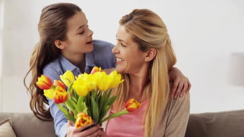 Loving Daughter Presents Flowers to Mother at Home