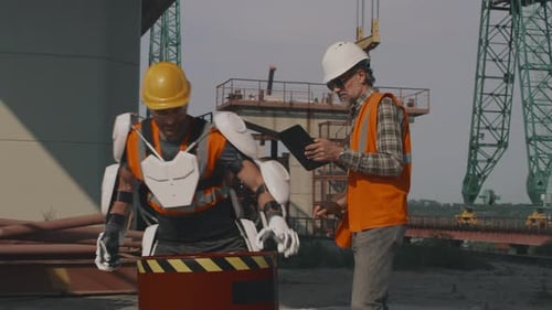 Man in Exoskeleton Lifts Barrel at Construction Site