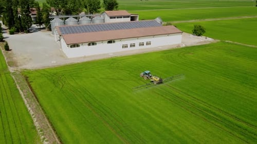Tractor and Farmer Spraying Fertilizer, Herbicide, Pesticide on Agriculture Farm Field