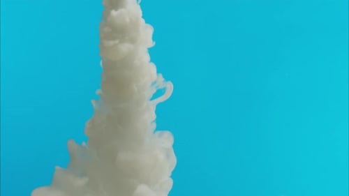 Jet de vapeur blanc sous l'eau sur fond bleu, brouillard de fumée, nuage de fumée blanc