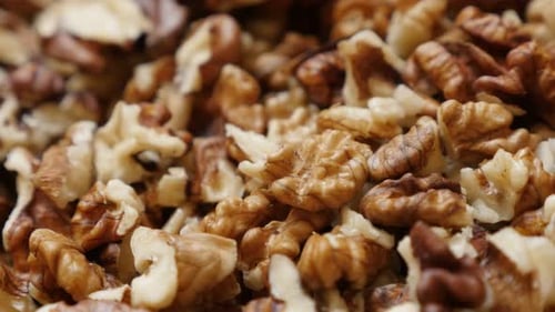 Juglans regia brown pieces shallow DOF 4K 2160p 30fps UltraHD pan footage - Healthy walnut out its