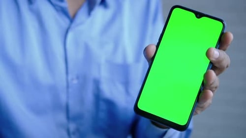 Close up of young man hand using smart phone with green screen