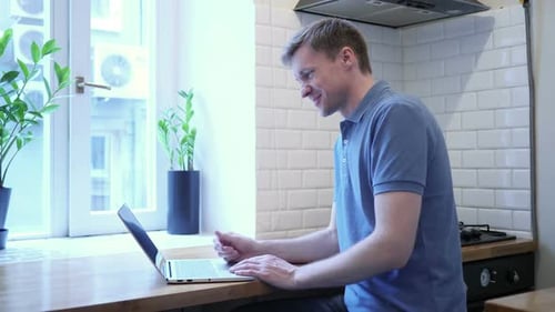 Man Working on Laptop during Video Conference at Home