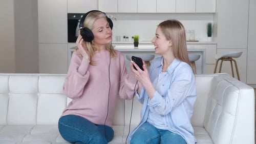 Mother and daughter listen to music indoors