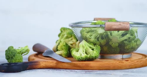 Close-up of Fresh Broccoli with Knife and Colander
