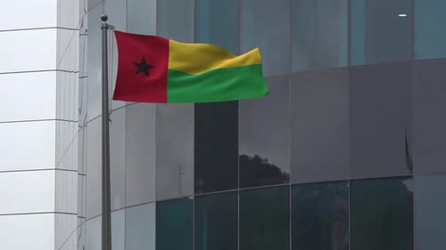 Waving Guinea-Bissau Flag on Modern Office Building