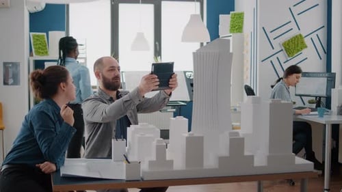 Man and Woman Analyzing Building Model and Maquette with Digital Tablet for Development