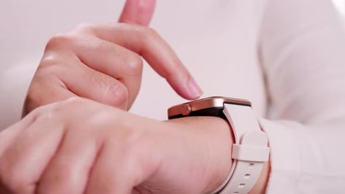 Close up shot of a woman hand who touch and scrolling on a smartwatch in order to quickly check appl