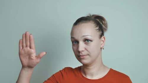 Woman Fists Hand Upward in Studio Setting