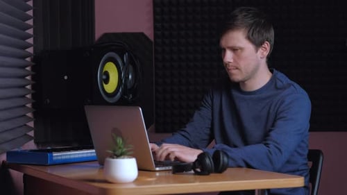 Sound Designer Working on Notebook in Music Studio