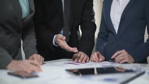 Zwei Manager-Damen und männlicher Chef vergleichen Verkaufscharts und Anlagepläne